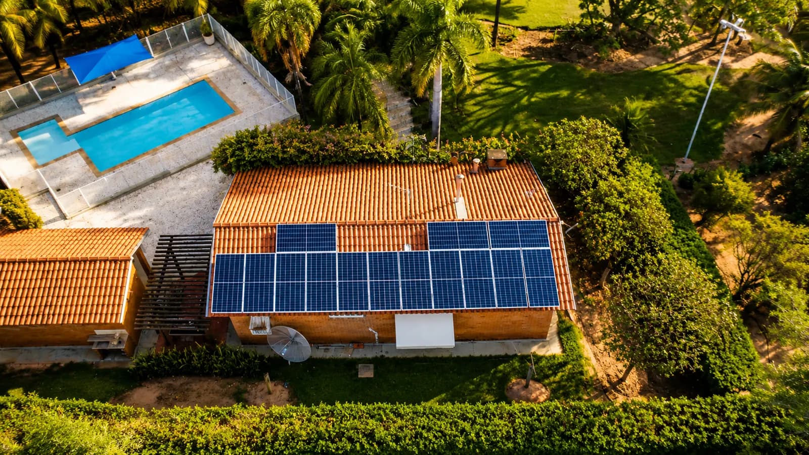 Vista aérea de casa com piscina e painéis solares no telhado